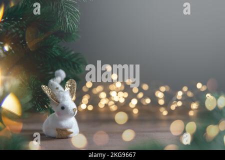 Un coniglio simbolo di 2023 tra le luci, ghirlande, alberi di Natale, calendario cinese anno simbolo con spazio copia Foto Stock