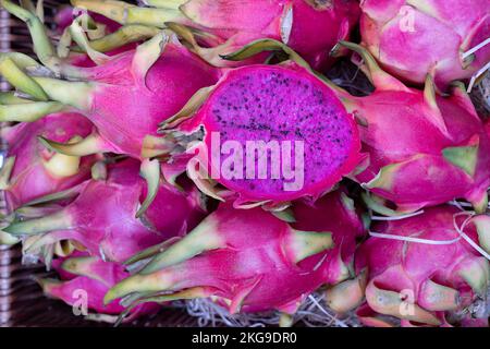 Frutti rossi del drago Ilocereus costaricensis o pitahaya un frutto tropicale. I frutti, un taglio a metà, sono in vendita in un mercato inglese di prodotti freschi Foto Stock