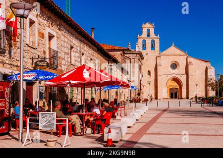 Pellegrini che riposano sulla vivace terrazza bar. Il Monastero di San Juan de Ortega è un monumento romanico a Barrios de Colina, Montes de Oca, Burgos, Cast Foto Stock