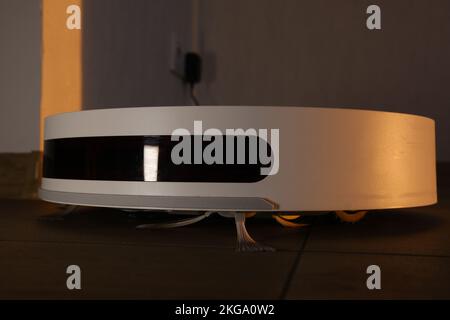 Donna pulisce il cestino automatico robot aspirapolvere Foto stock - Alamy