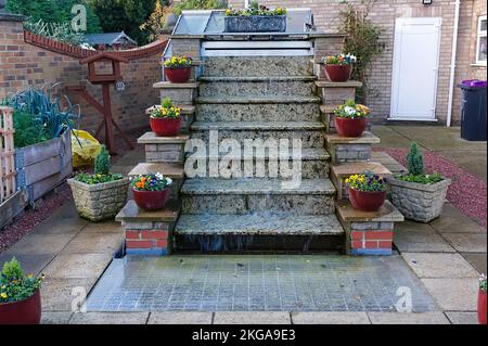 splendida cascata di gradini in un giardino con piante simmetriche in vaso su ogni lato Foto Stock