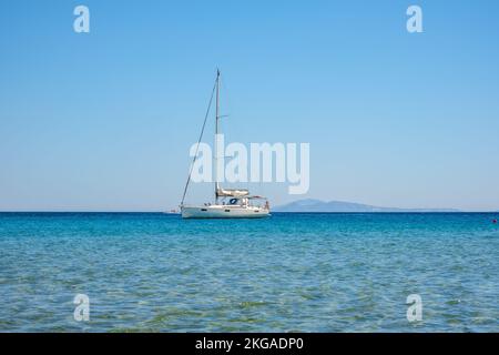 IOS, Grecia - 14 settembre 2022 : una barca a vela presso la famosa spiaggia di Mylopotas in Grecia Foto Stock