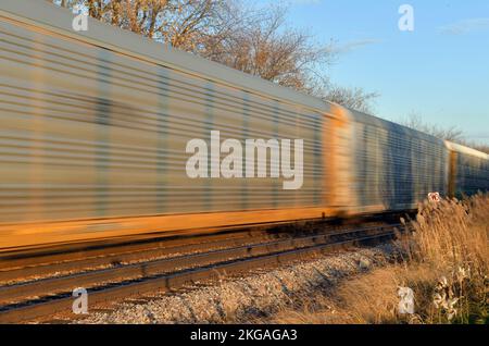 Bartlett, Illinois, Stati Uniti. Un treno merci, offuscato dal suo movimento, che passa attraverso l'Illinois nord-orientale. Foto Stock