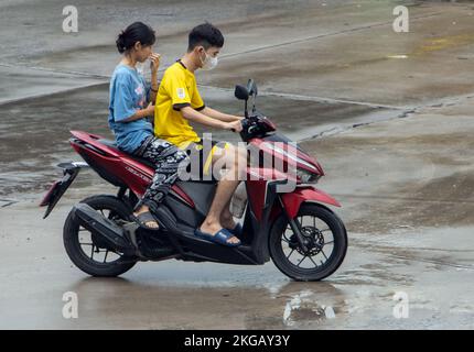 SAMUT PRAKAN, THAILANDIA, 29 2022 SETTEMBRE, la coppia cavalca in moto sulla strada bagnata. Foto Stock