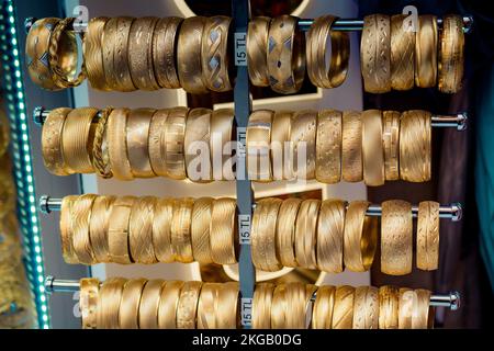 Display negozio di decine di golden Bracciali e schiave Foto Stock