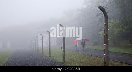 Recinto del campo ricostruito con persone nella nebbia al campo di concentramento della foresta di faggi, ora un memoriale del campo di concentramento, Weimar, Turingia, Germania, EUR Foto Stock