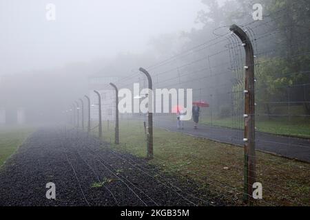 Recinto del campo ricostruito con persone nella nebbia al campo di concentramento della foresta di faggi, ora un memoriale del campo di concentramento, Weimar, Turingia, Germania, EUR Foto Stock
