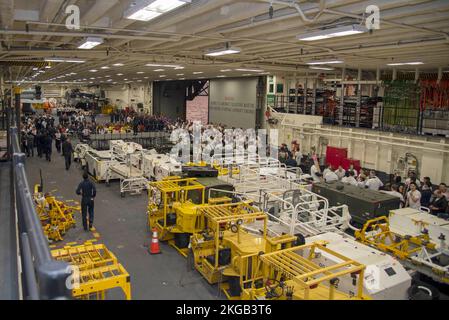 221118-N-XN177-1030 OCEANO PACIFICO (18 novembre 2022) – marinai e Stati Uniti I Marines assegnati alla nave d'assalto anfibio USS Tripoli (LHA 7) si riuniscono nella baia di hangar per lo spettacolo di talenti del pollywog come parte della cerimonia di attraversamento della linea 18 novembre 2022. Tripoli sta conducendo operazioni di routine nella U.S. 3rd Fleet. (STATI UNITI Foto Navy di Mass Communication Specialist 1st Classe Peter Burghart) Foto Stock