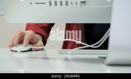 Donna lavora su un grande personal computer bianco. Primo piano Foto Stock