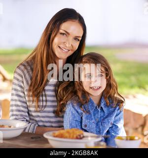 Tempo prezioso di incollaggio. Ritratto di una madre e di una figlia che gustano la colazione insieme fuori. Foto Stock