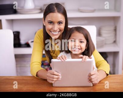 Qual è la tua app preferita. Una madre e una figlia che lavorano insieme su un tablet. Foto Stock