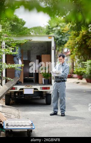Movimentare il riempimento dei documenti dopo aver caricato il furgone con scatole di cartone Foto Stock