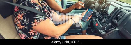 Donne che guardano il gps sul cellulare durante un viaggio in camper Foto Stock