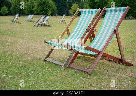 Una selezione di sedie a sdraio a strisce bianche e blu chiaro in Hyde Park Foto Stock