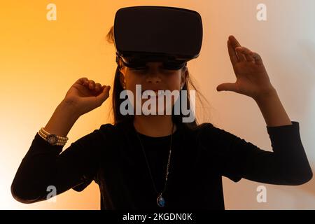 una bambina stupita indossa occhiali vr utilizzando la tecnologia per l'istruzione nella realtà virtuale, nel mondo virtuale. Banner di bambina con realtà virtuale vr Foto Stock