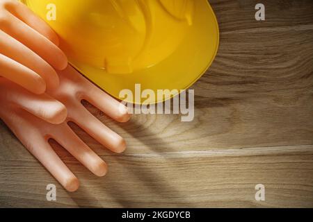 Guanti dielettrici che costruiscono il casco su una tavola di legno. Foto Stock