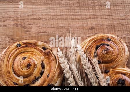 Panetteria di uva passa alle spighe dorate su tavola di legno di legno di oaken concetto di cibo e bevande. Foto Stock