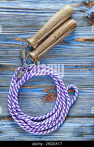 Corda da salto su una tavola di legno vintage blu. Foto Stock