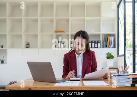 donna ragioniere di affari che fa le finanze e calcola sulla scrivania circa il costo in ufficio. Foto Stock