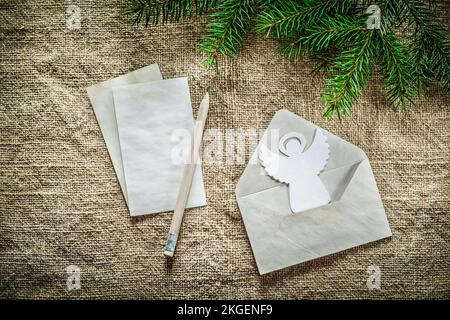 Pino ramo busta lettera matita angelo su sfondo saccheggio. Foto Stock