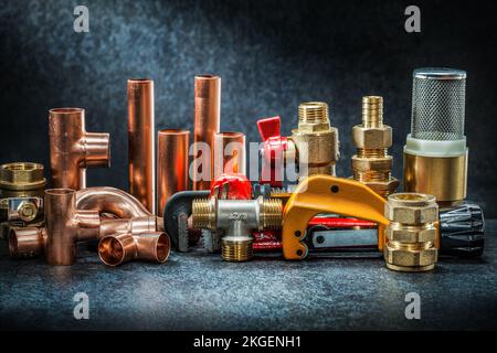 tagliatubi e chiave regolabile con connettori in rame ottone, grande set su fondo scuro Foto Stock