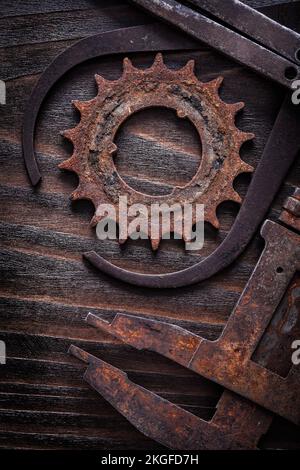 Versione verticale di pinze di misura arrugginite con ruota dentata su bordo di legno scuro vintage concetto di costruzione. Foto Stock