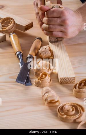 vista molto ravvicinata sulle mani del falegname con pialla e scalpelli Foto Stock