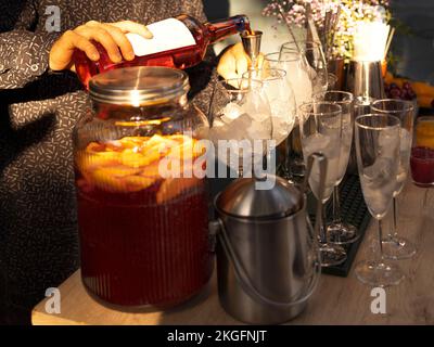 Bicchieri di cocktail al bar. Il barista versa un bicchiere di spumante con l'alcol rosso. Barman preraring aperol spritz cocktail in estate all'aperto Foto Stock