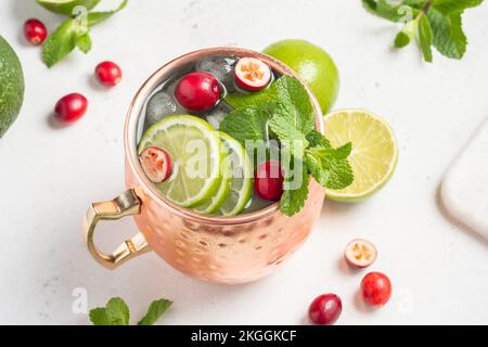 Natale Mosca Mule cocktail con mirtilli rossi e lime in tazze di rame per Natale Foto Stock