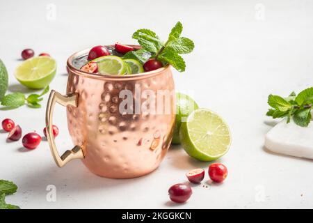 Natale Mosca Mule cocktail con mirtilli rossi e lime in tazze di rame per Natale Foto Stock