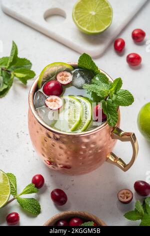 Natale Mosca Mule cocktail con mirtilli rossi e lime in tazze di rame per Natale Foto Stock