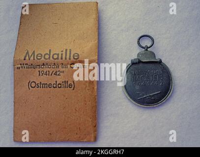 Un'antica medaglia di guerra tedesca della seconda guerra mondiale con il corrispondente sacchetto di carta marrone. Medaglia orientale o Battaglia invernale in Oriente 1941–42 Medaglia Foto Stock