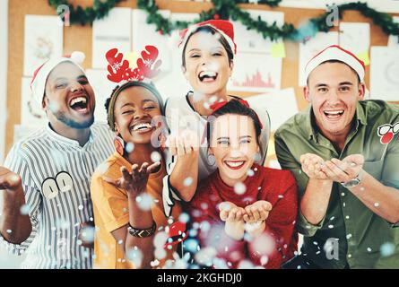 Natale, ufficio e uomini d'affari che soffiano i confetti e che si divertono insieme. Ritratto, festa di Natale o gruppo di dipendenti felici, lavoratori o colleghi Foto Stock
