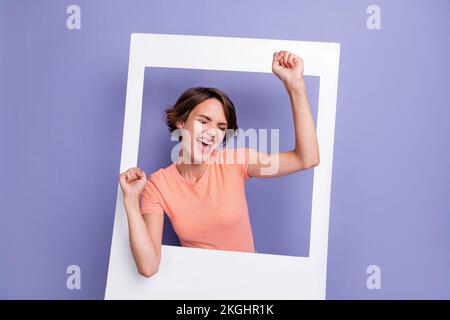 Foto di allegro overjoyed signora occhi chiusi sollevare mano godere successo campione urlare si hooray isolato su sfondo di colore viola Foto Stock