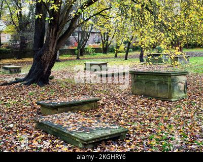 Tombe sotto l'albero autunnale alla chiesa di St Johns in Knaresborough North Yorkshire Inghilterra Foto Stock