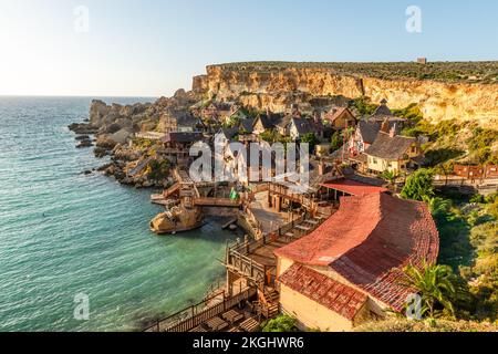 Il-Mellieha, Malta - Vista panoramica dello skyline del famoso Popeye Village a Anchor Bay al tramonto. Foto Stock