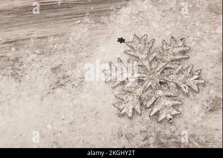 Natale sfondo grigio legno con neve artificiale e fiocco di neve argento Foto Stock