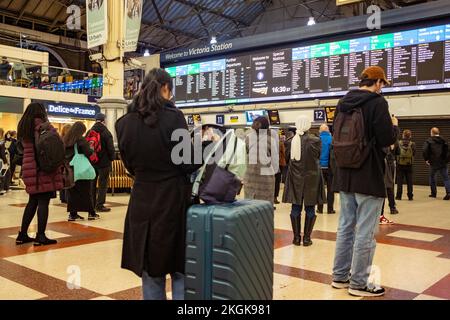 Londra - Dicembre 2022: Passeggeri in attesa di informazioni sul treno sull'atrio principale della Victoria Station a Westminster. Foto Stock