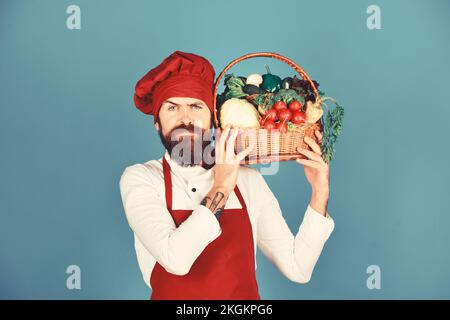 Concetto di cucina sana. Cuocete con il volto stretto in uniforme bordeaux Foto Stock