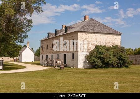 L'edificio principale del sito storico nazionale di Lower Fort Garry con un carretto rosso sul fiume di fronte ad esso Foto Stock