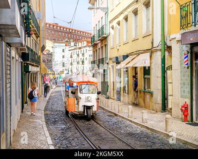 Street Scene con un Tuk Tuk che trasporta turisti in tutta Lisbona per visite turistiche, il trasporto più veloce e meno costoso a Lisbona, Lisbo Foto Stock