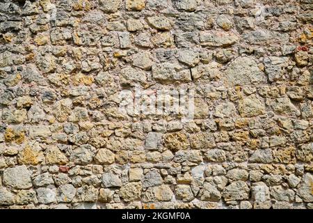 Marrone rustico muro di pietra di un vecchio castello. Sfondo di pietra. Foto Stock