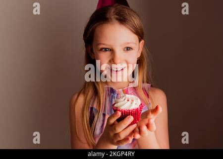 Ritratto di felice bambina con torta di tazza Foto Stock