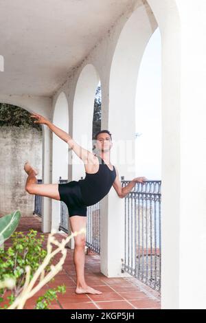 Ballerino maschile praticando da ringhiera sul portico Foto Stock