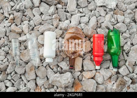 Bottiglie di plastica vuote su pietre in spiaggia Foto Stock