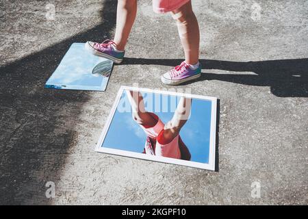 Donna che indossa gli specchi con scarpe da tela Foto Stock