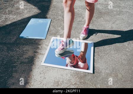 Donna che indossa gli specchi con scarpe da tela Foto Stock