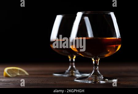 Due bicchieri di cognac sono su un tavolo di legno Foto Stock