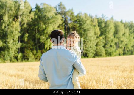 Padre che porta la figlia in campo il giorno di sole Foto Stock