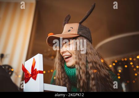 Donna felice che tiene il regalo di Natale nel paese Foto Stock